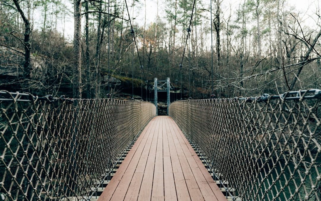 a wooden bridge surrounded by a chain link fence