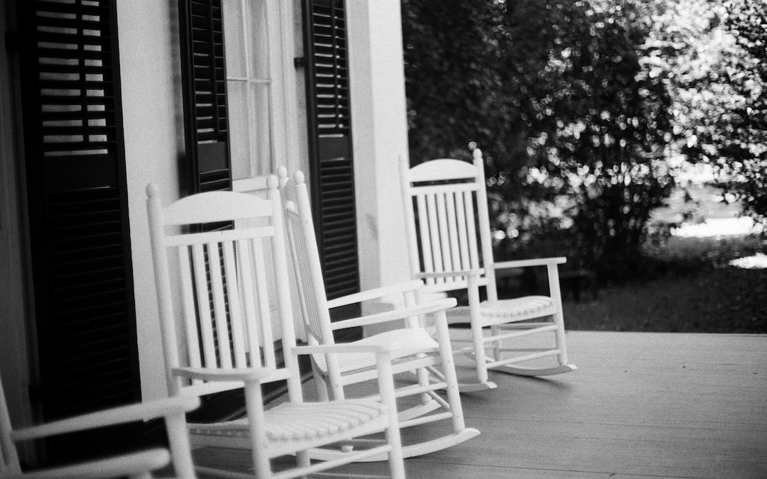 grayscale photo of two rocking chairs