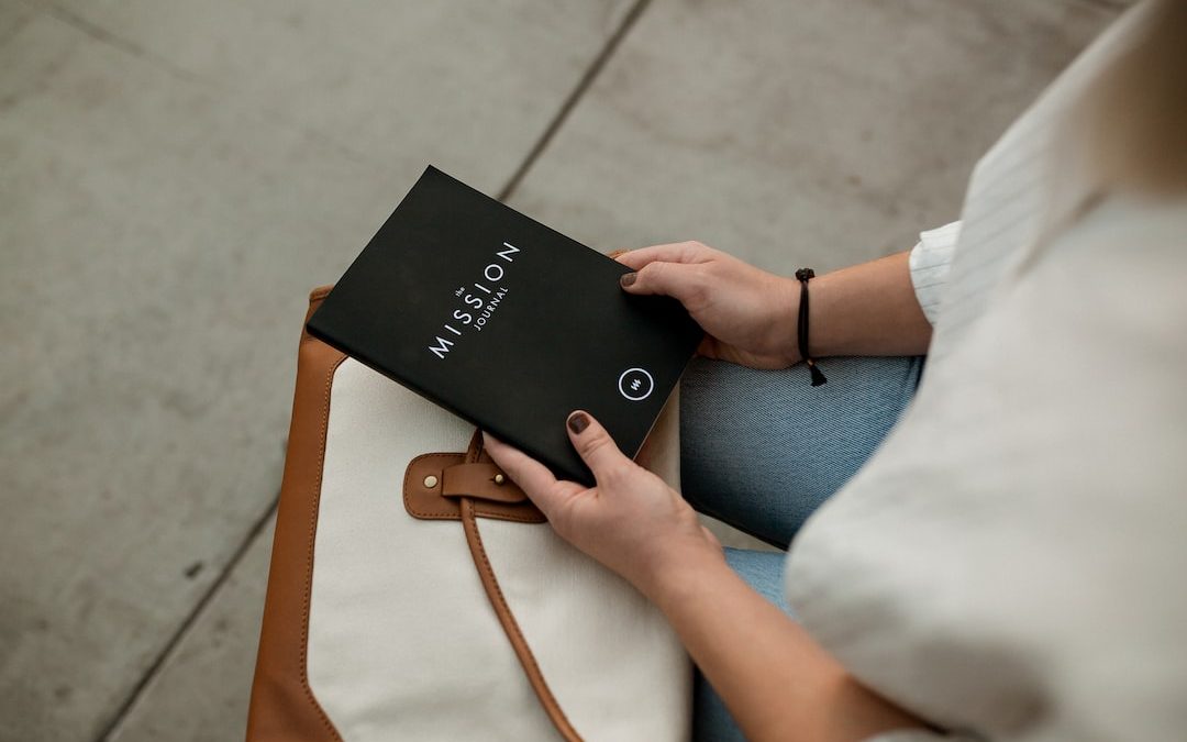 woman holding black Mission book