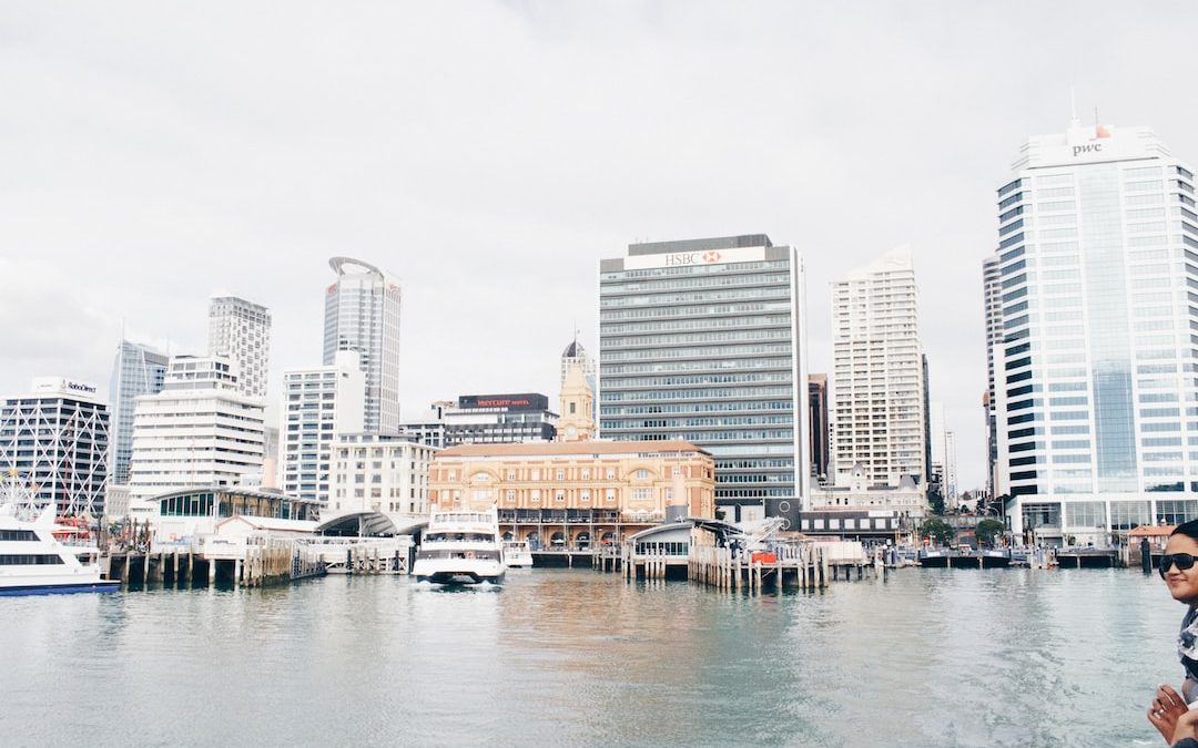 white ship on body of water in front of building