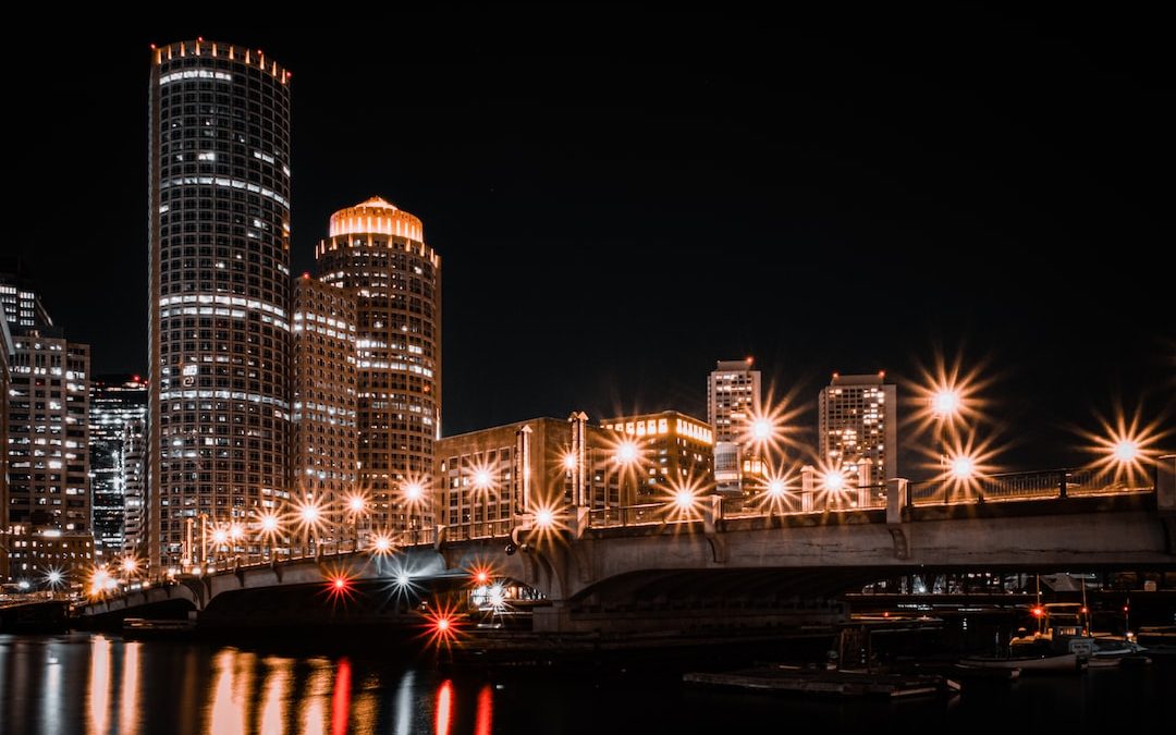 a night scene of a city with a bridge over a body of water