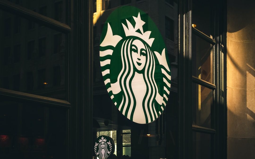 a starbucks sign hanging from the side of a building