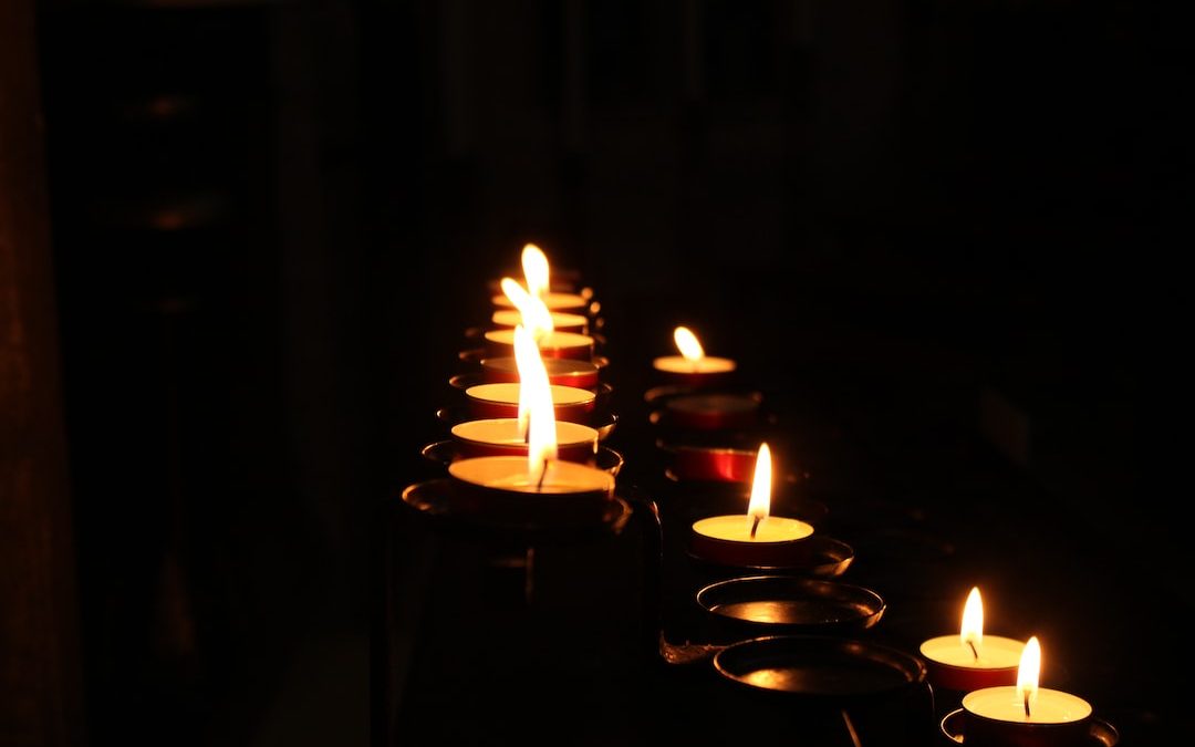 a row of lit candles in a dark room