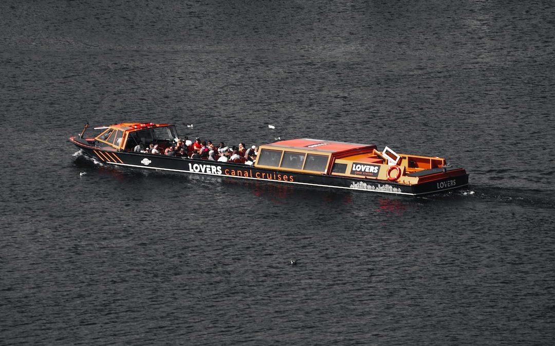 a boat full of people sailing on the water