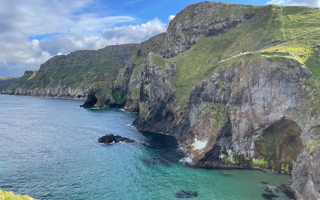 a rocky cliff next to a body of water