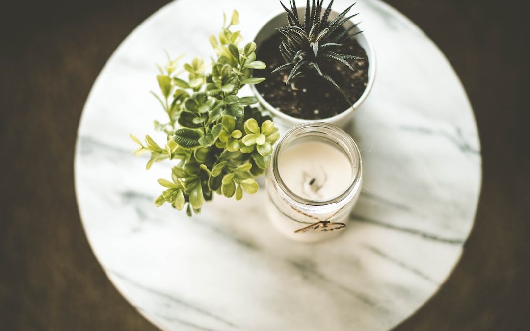 white votive candle near plant pot