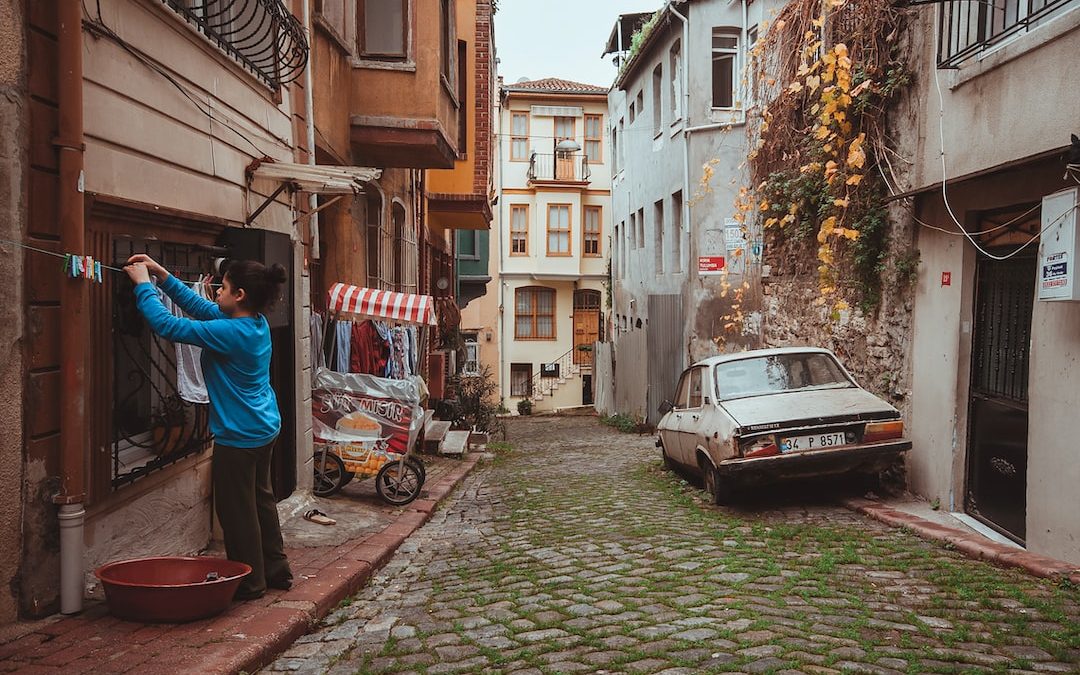 a man taking a picture of a car in a narrow alleyway