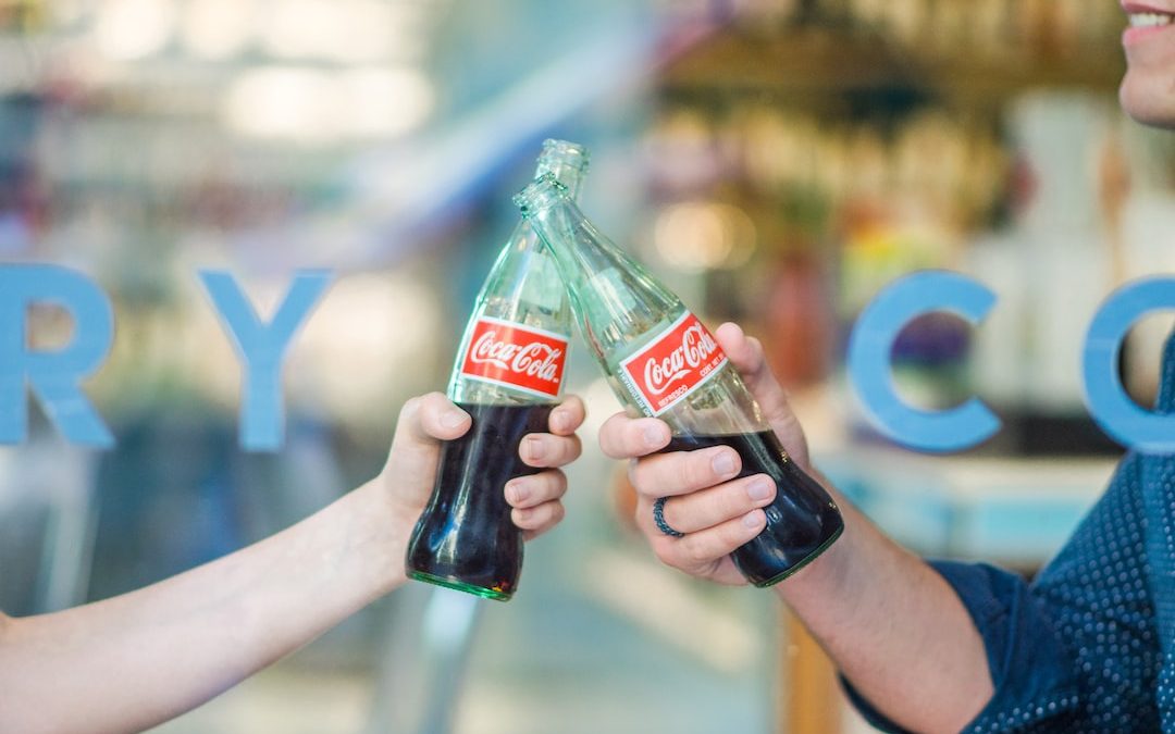 person holding Coca-Cola bottle