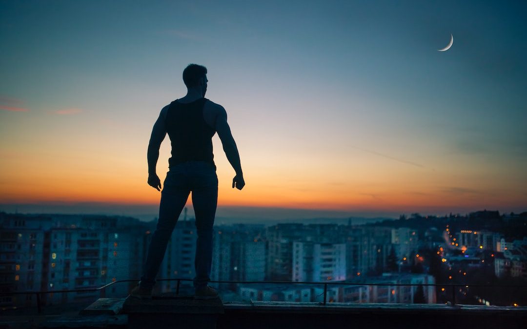 silhouette photography standing on peak front of high-rise buildings