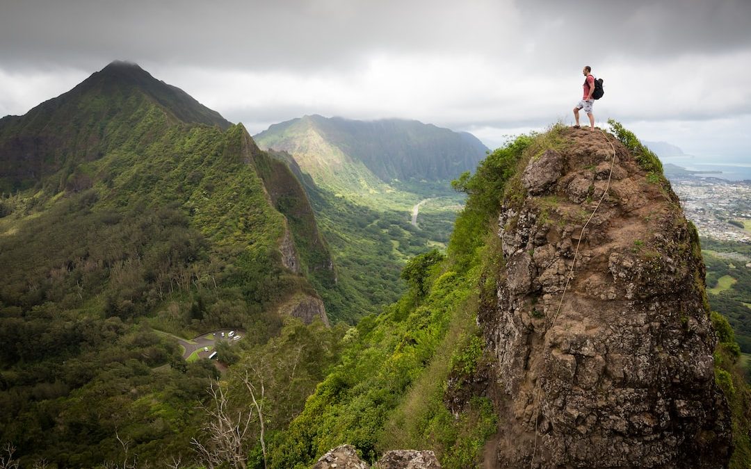 man on top of the mountain during daytime