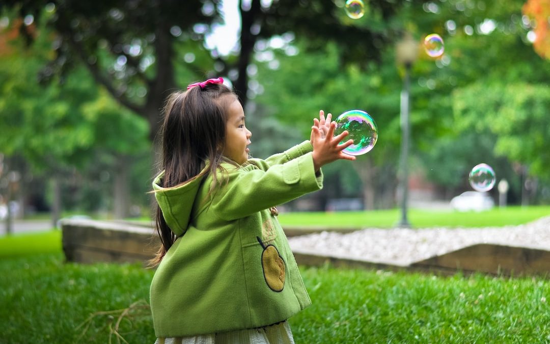 selective photo of a girl holding bubbles