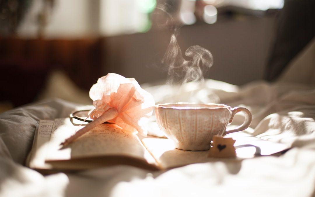 teacup on book beside pink flower decor