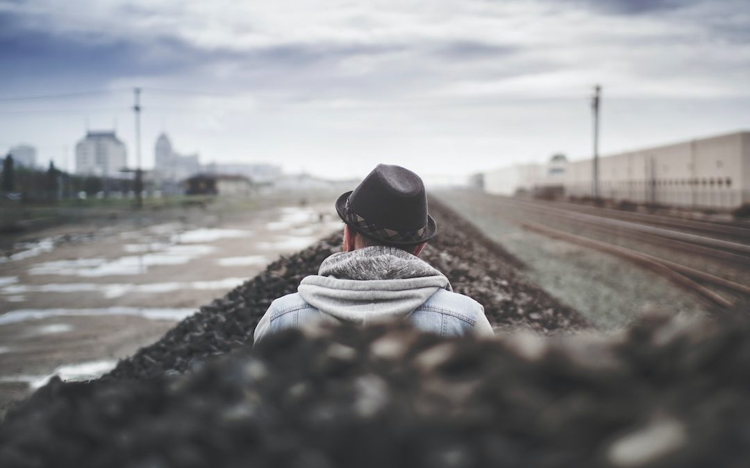 selective focus of man sitting beside body of water