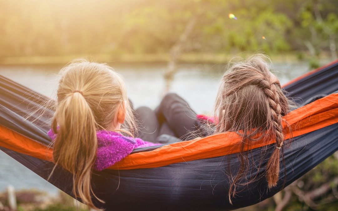 two women lying on hammock