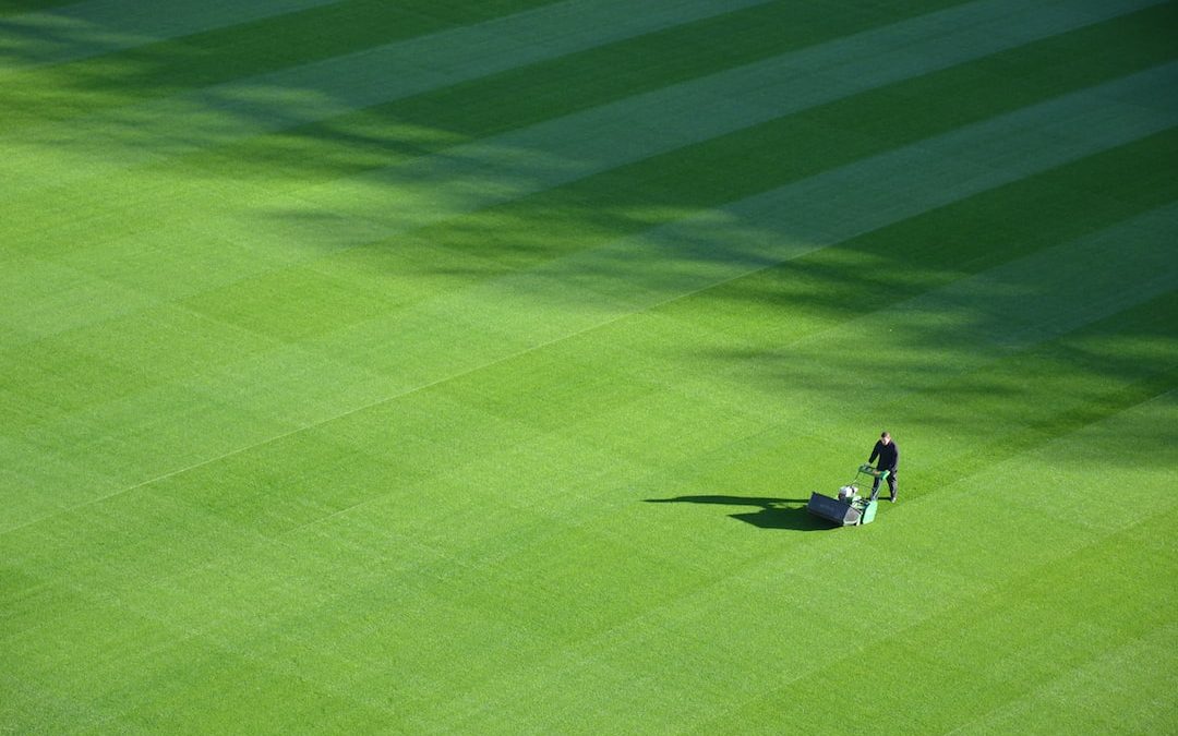 aerial photography of person trimming sports field during day