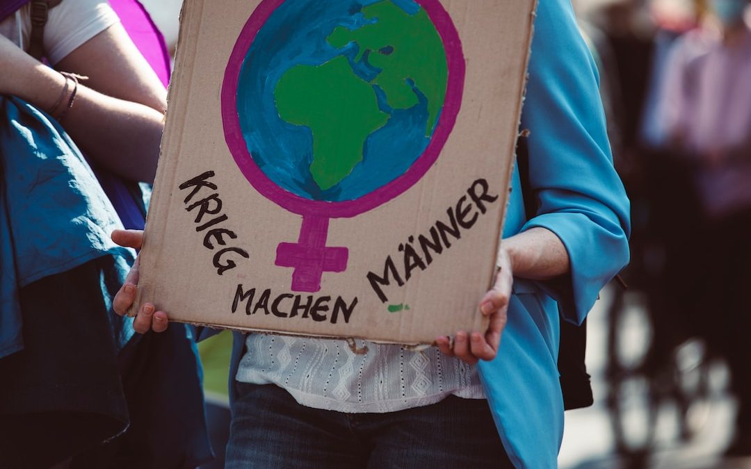 a person holding a cardboard sign with a picture of the earth on it