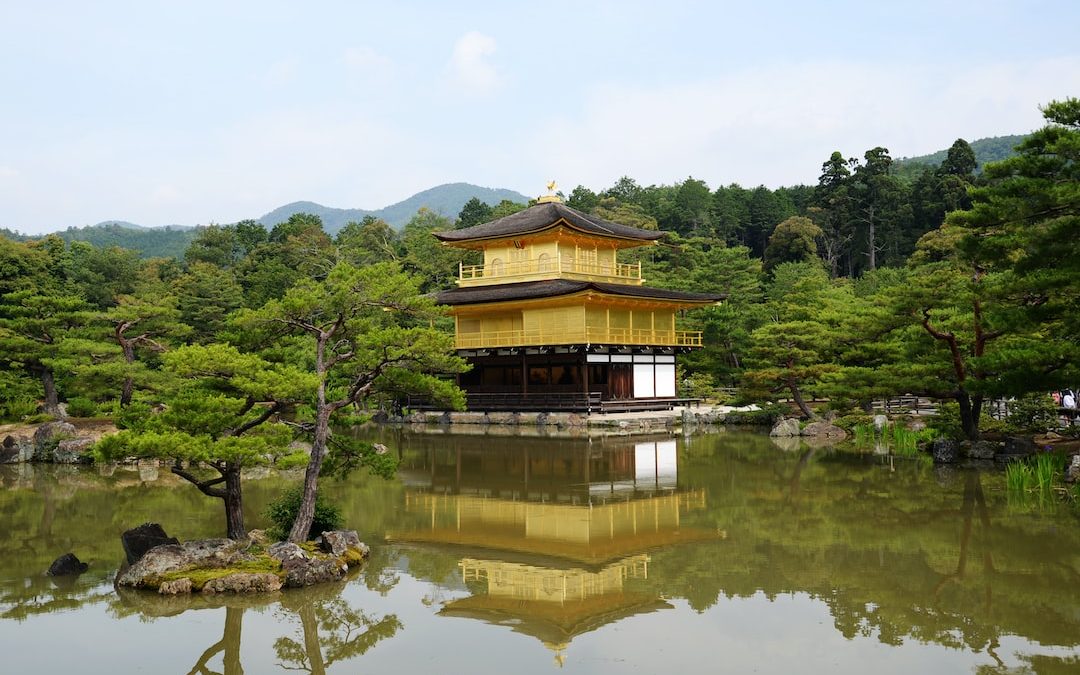 a pagoda in the middle of a pond surrounded by trees