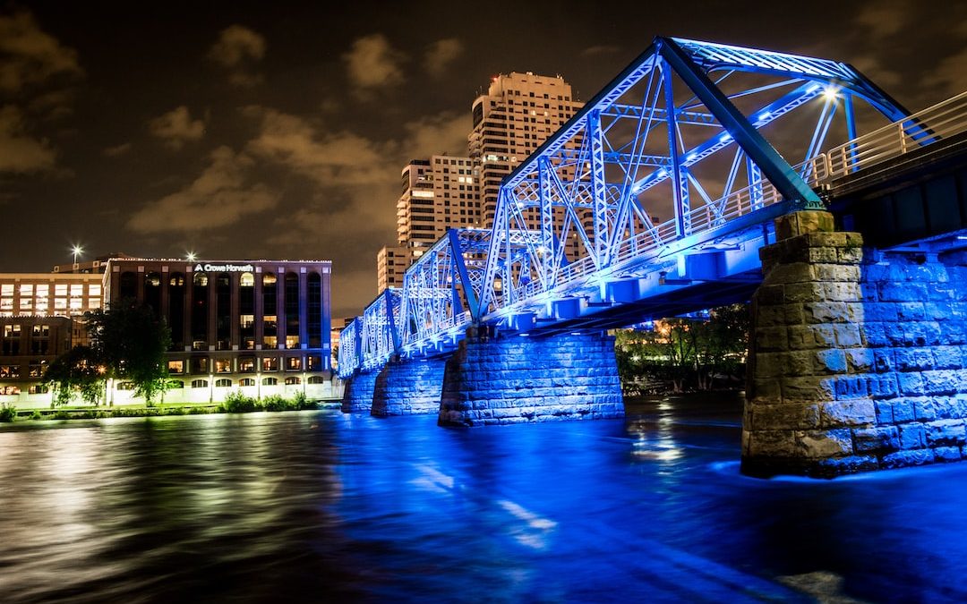 bridge over body of water leading to buildings during nighttime