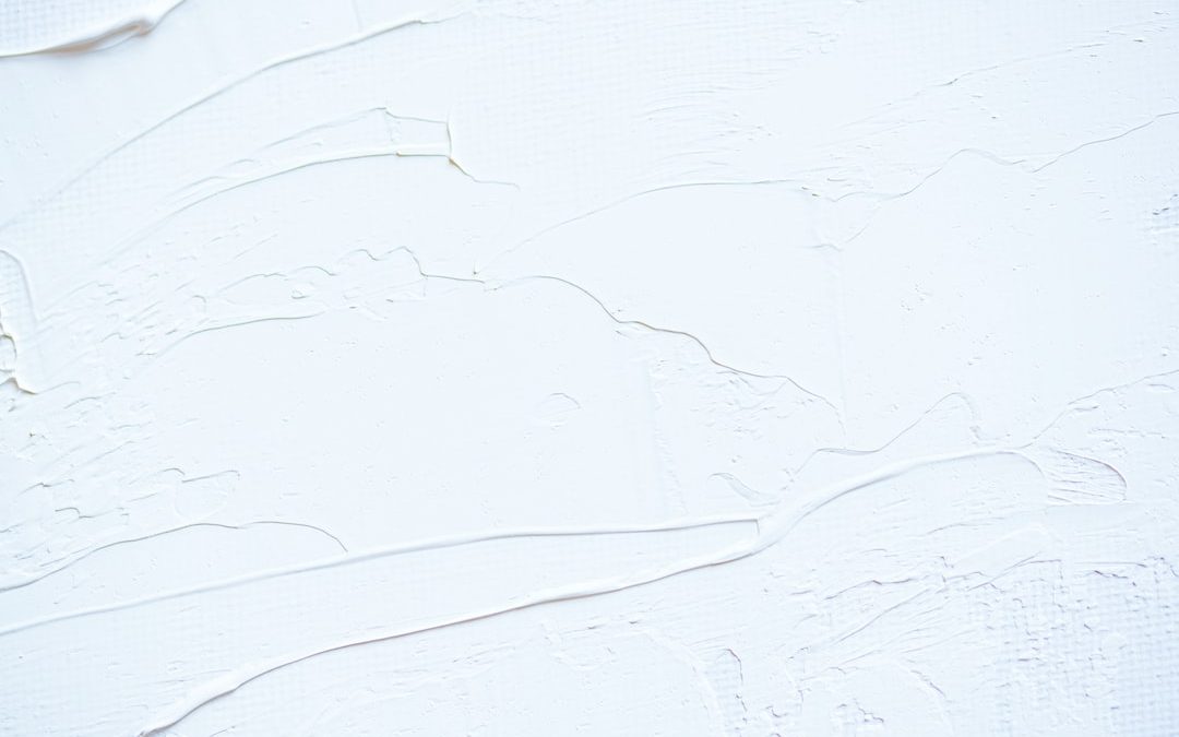 a close up of a white wall with peeling paint