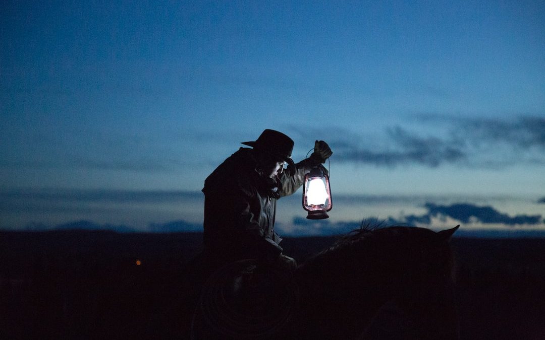 horseback riding cowboy holding a lamp