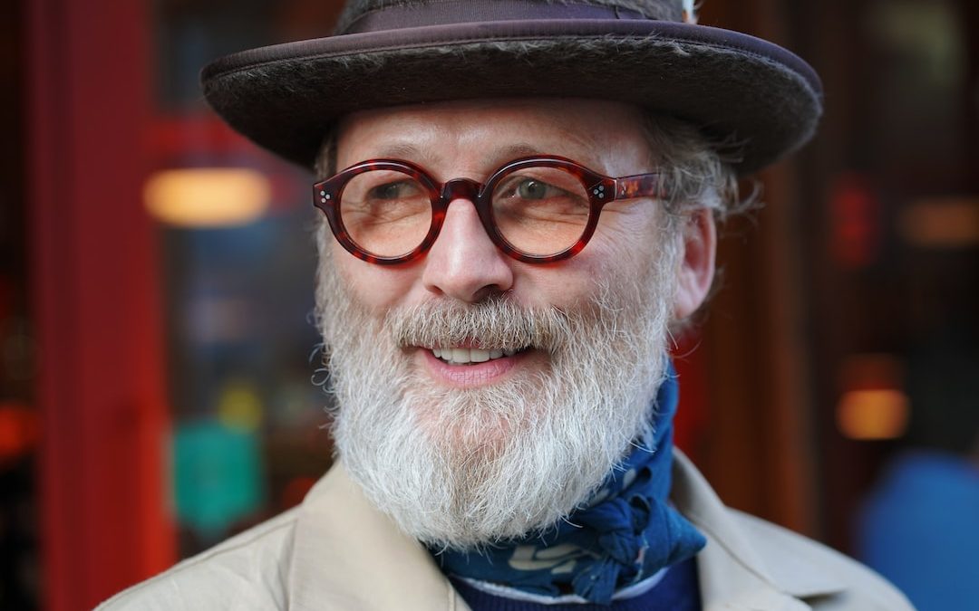 man in brown coat wearing black framed eyeglasses