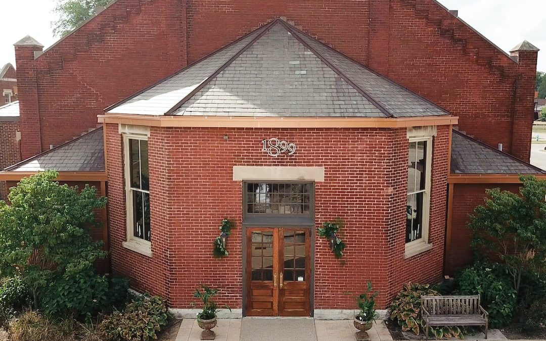 a red brick building with a bench in front of it