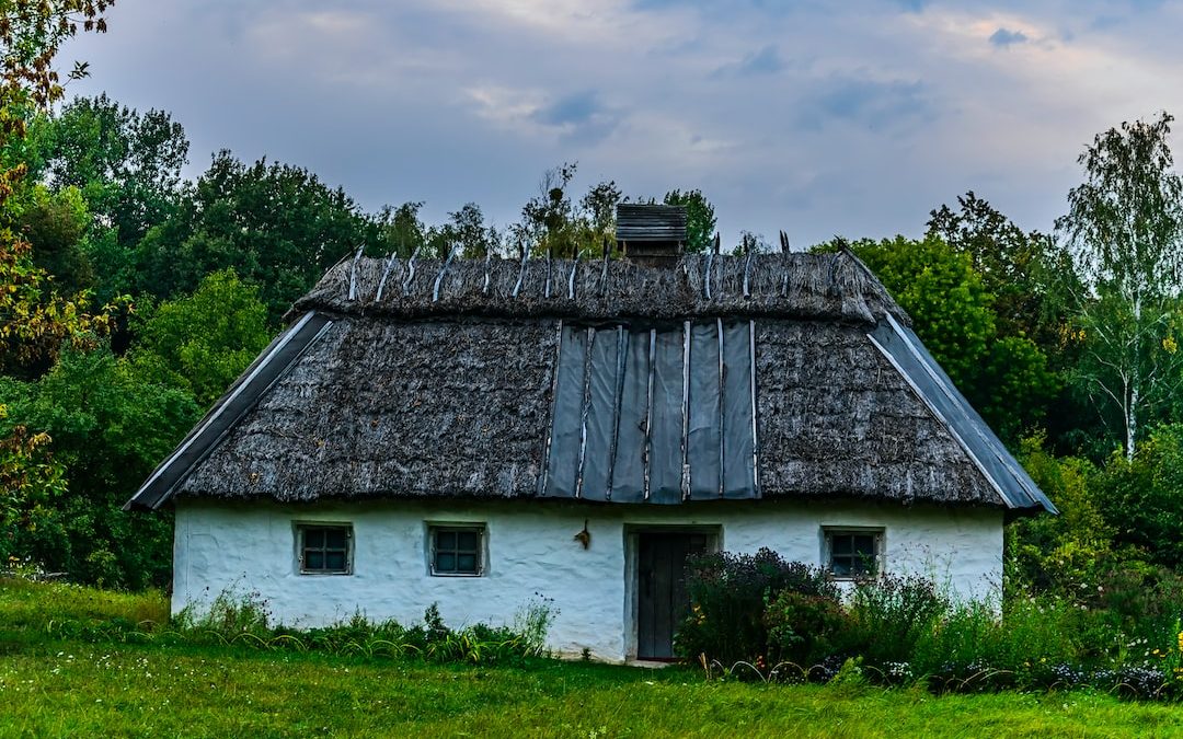 a small white house with a thatched roof