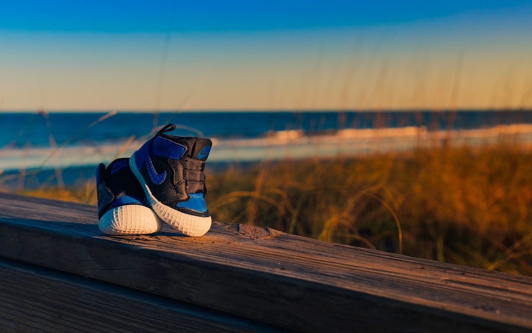 white and blue adidas sneakers on brown wooden plank during daytime