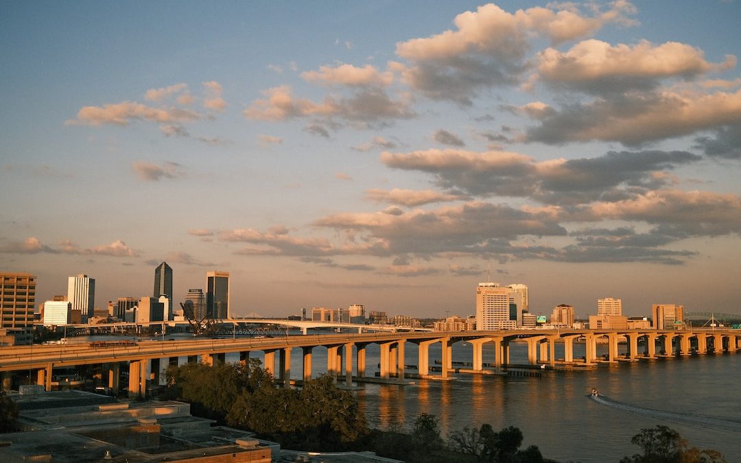 a bridge over a river with a city in the background