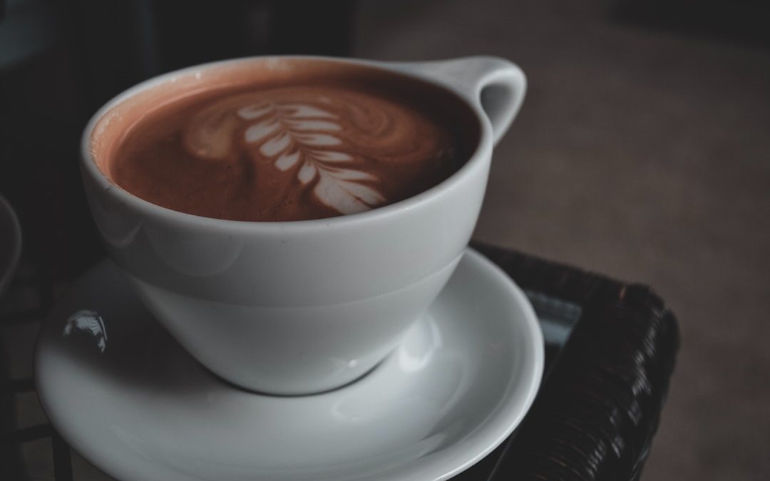 food photography of white ceramic mug with brown liquid