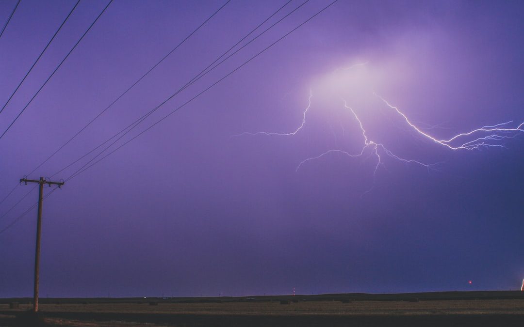 a lightning bolt is seen in the sky above a road