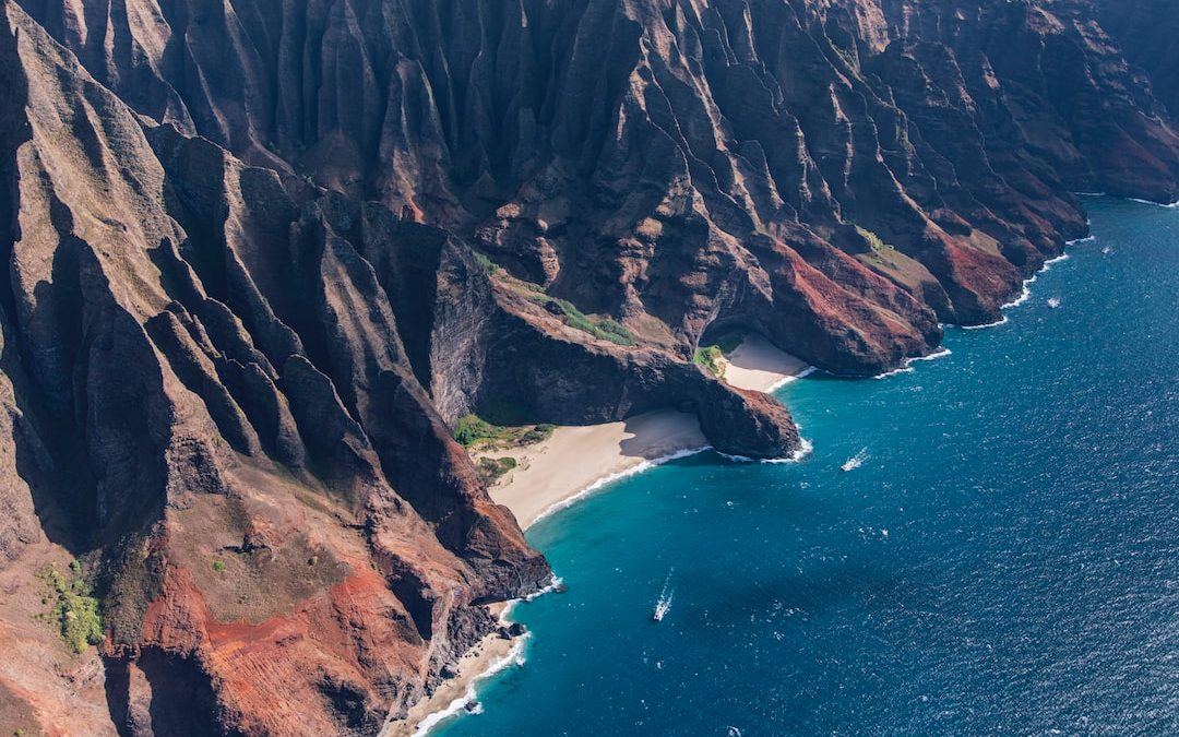 a rocky cliff next to a body of water