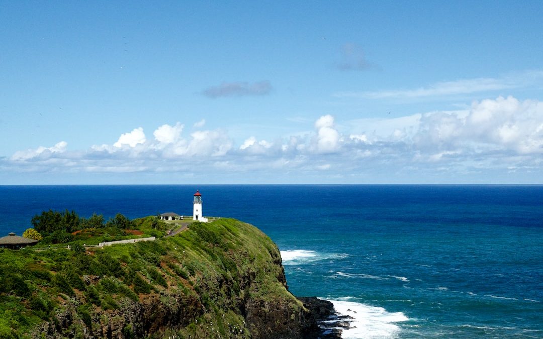 white lighthouse on rock formation