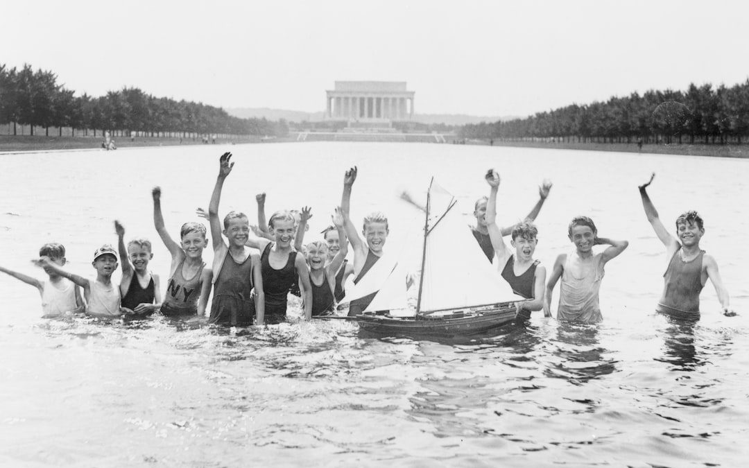 Group of boys waving as they play in the reflecting pool in front of the Lincoln Memorial