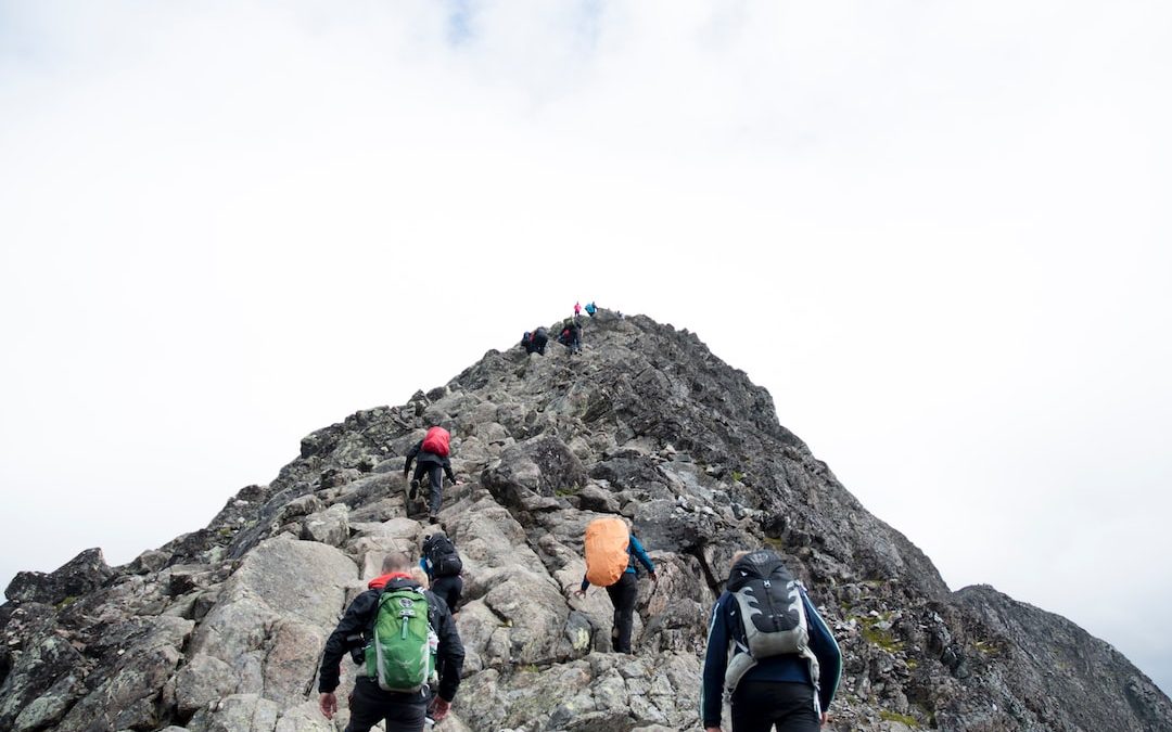 climbers hiking through mountain peak during daytime