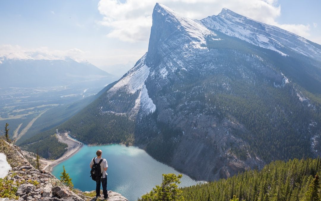 aerial photography of man standing on hill