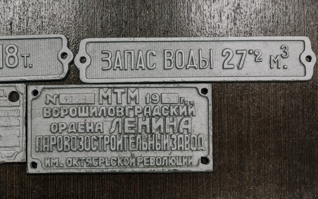 a couple of metal signs sitting on top of a wooden table