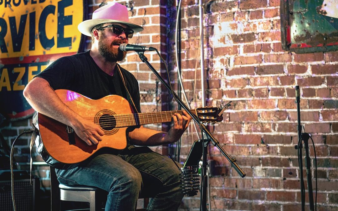 man playing guitar while singing