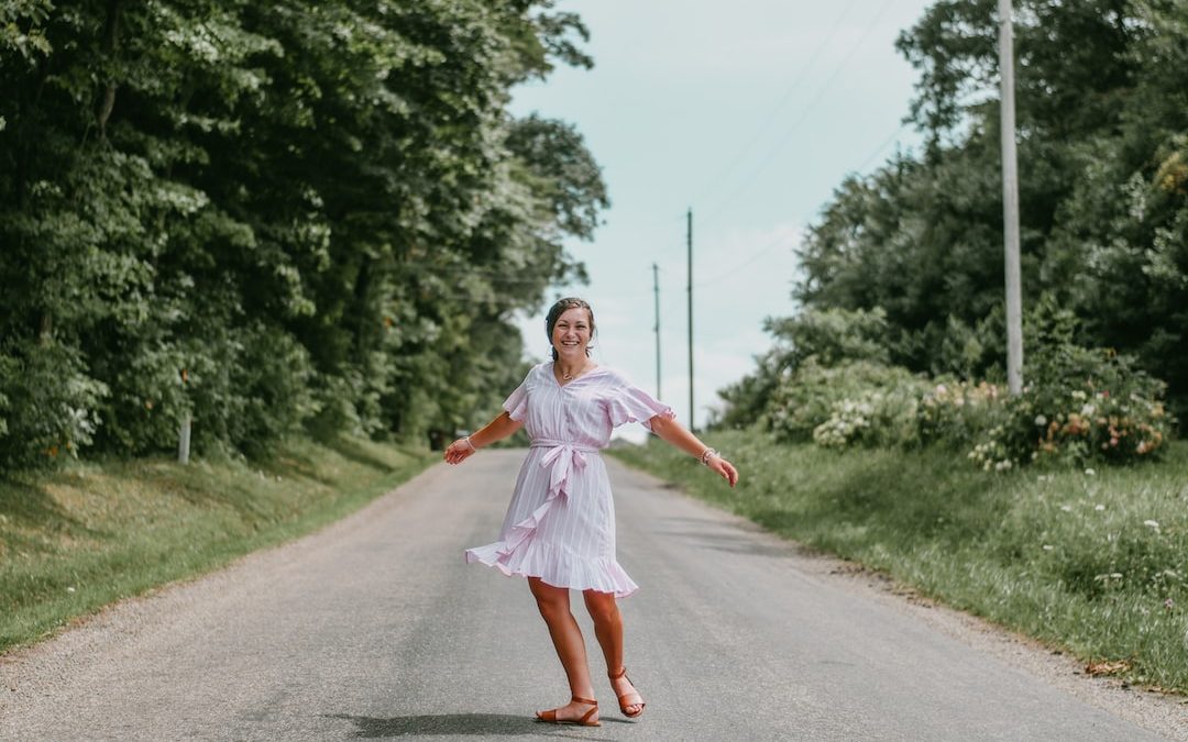 girl in pink dress running on road during daytime