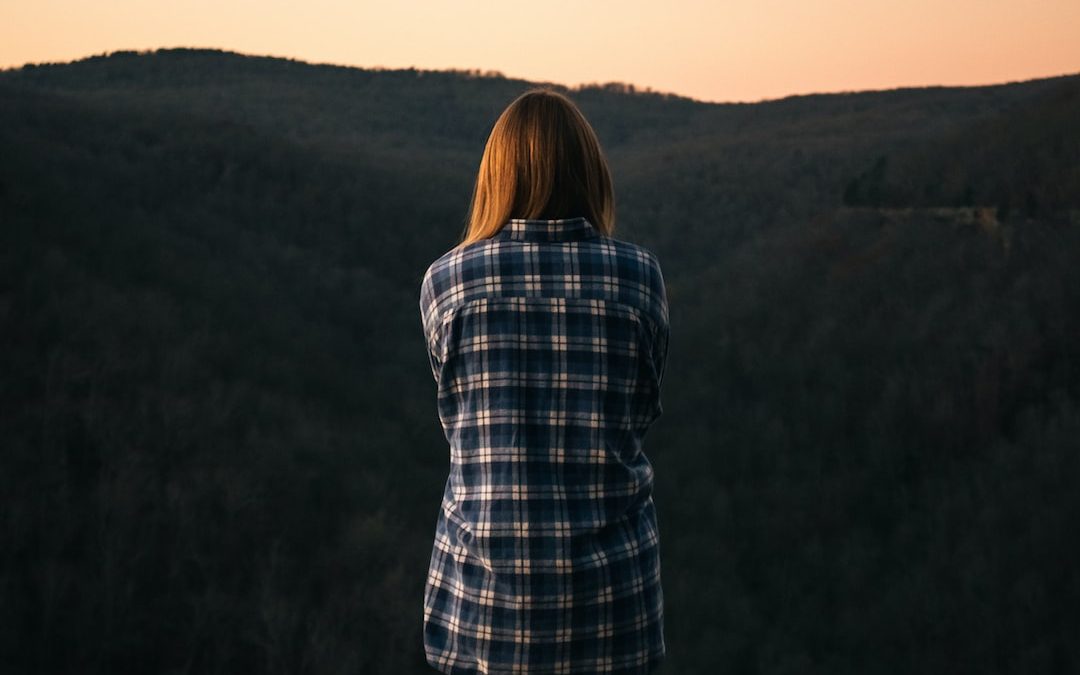 woman standing while facing the mountain