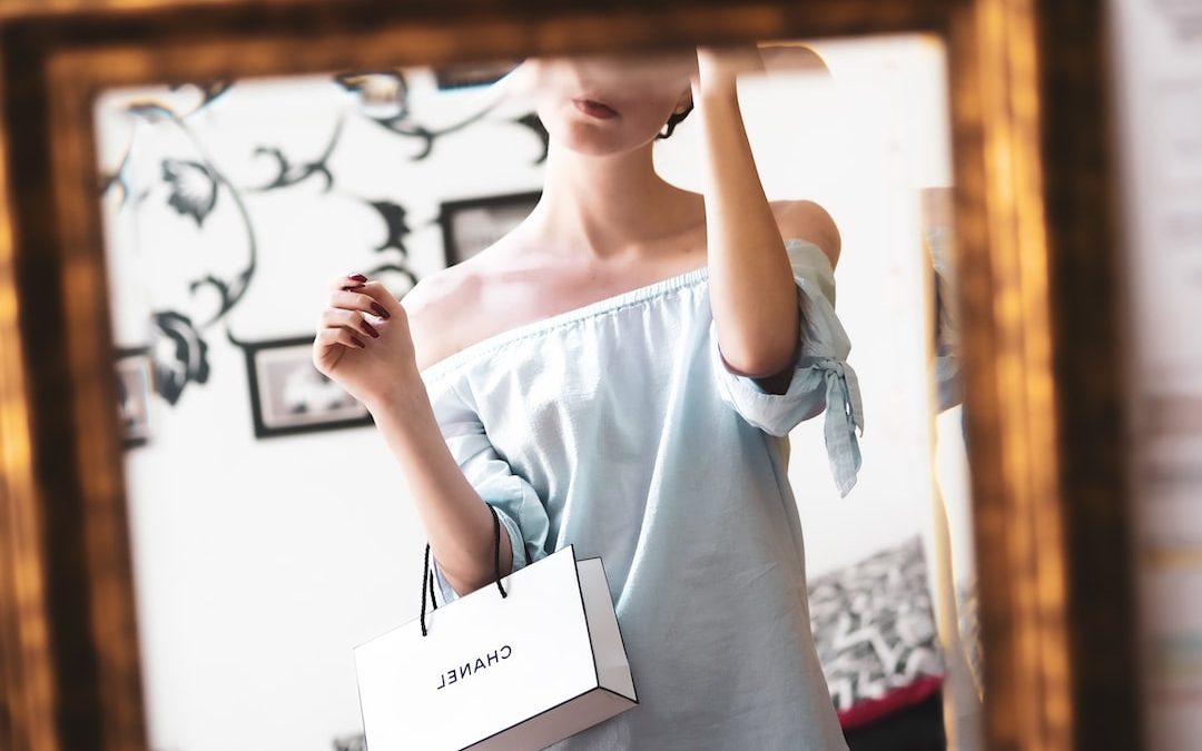 woman in white tank top holding white printer paper