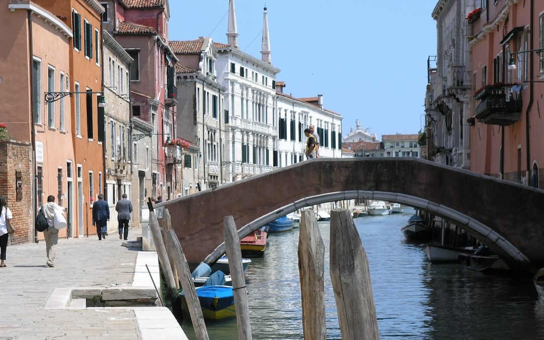 people walking on bridge and near water canal