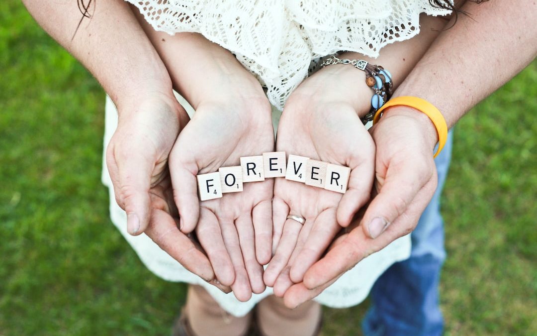 adult and girl holding forever scrabble letters during daytime