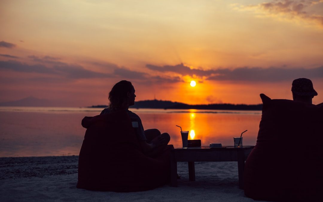 silhouette of person sitting on chair during sunset