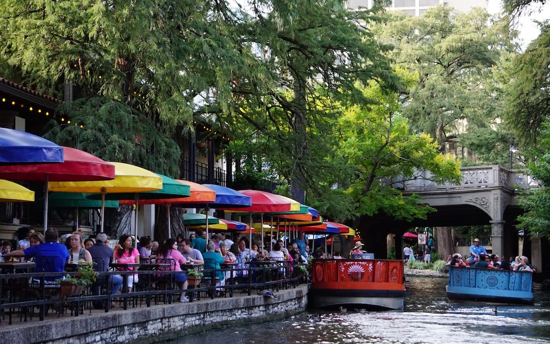 people riding on red boat on river during daytime