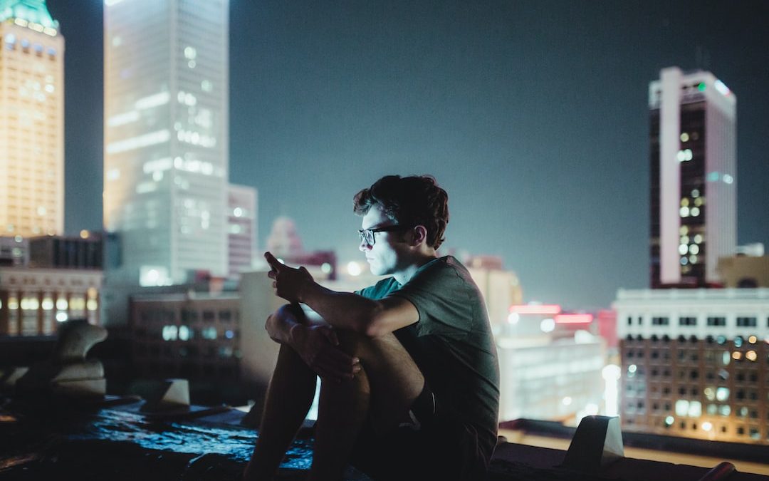 man sitting on top of building during nighttime
