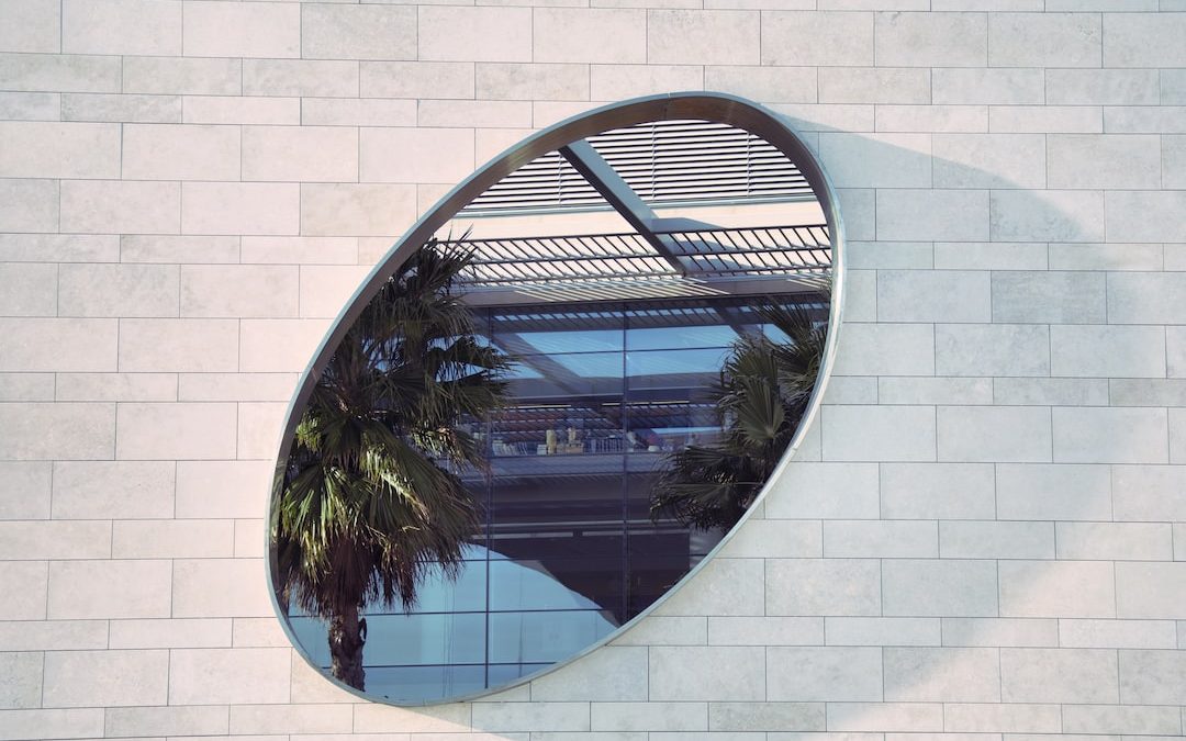 oval mirror on white brick pathway