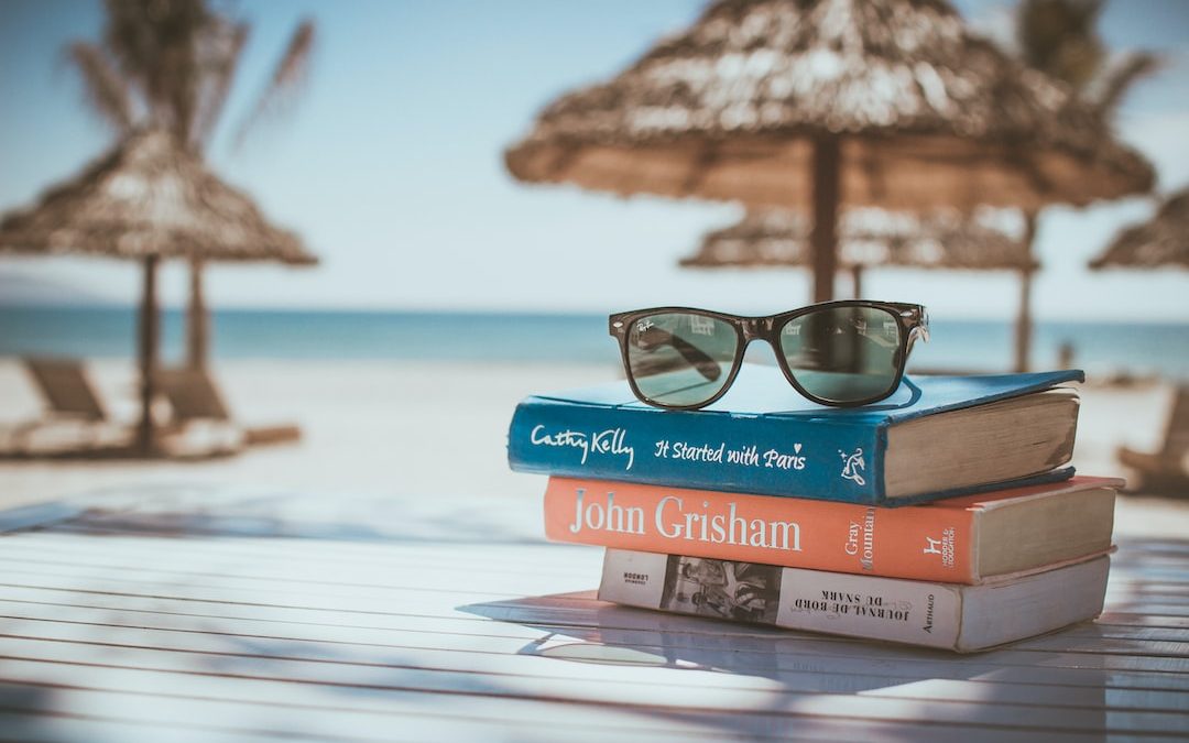 black framed Ray-Ban Wayfarer sunglasses on top of book