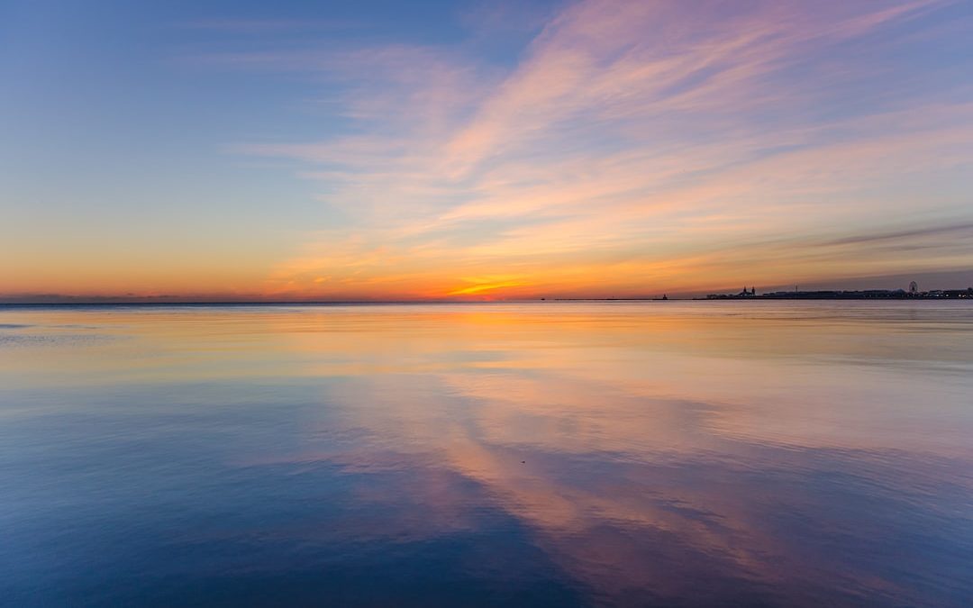 body of water under cloudy sky