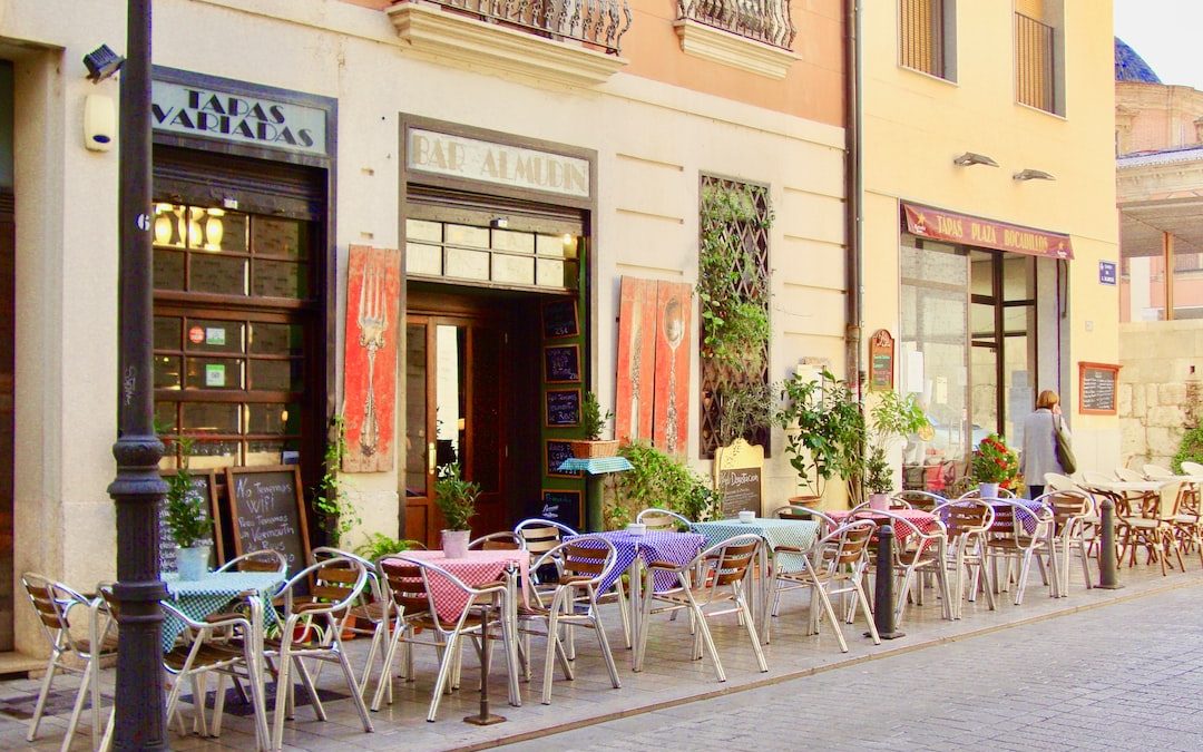 a row of tables and chairs outside of a building